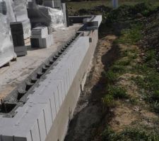 La première rangée terminée : au premier plan l'isolant et, en arrière, le bloc bois ciment avec sa cavité de 12 cm de large qui sera ensuite remplie de béton.