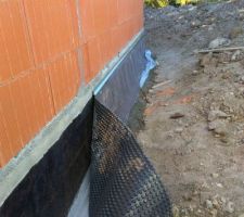 Une feuille M.S par dessus le goudron en cours de pose