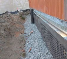 Le haut du M.S fixé par un arrêt de crépis en inox.Au pied cailloux enrobant le tube de drain