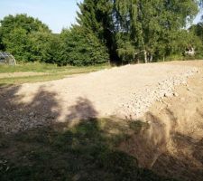 Aplanissement et tassement des cailloux avec la pelleteuse