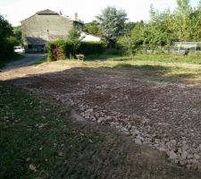 Aplanissement et tassement des cailloux avec la pelleteuse