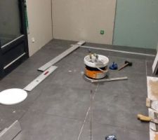 Pose du carrelage de la buanderie en cours. Carreaux de 60×60.