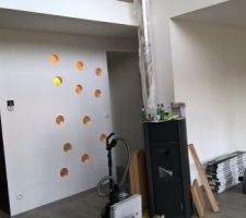 Le mur de la salle de bain du bas était plein.
Pour y amener de la lumière, il a été percé de trous à la scie cloche. on y a installé les vases dans lesquels on avait fait le salad bar à notre mariage.