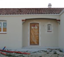 Crépi terminé (extra-blanc qui fait beige car il n'est pas encore sec) et gouttières posées sur la façade Nord-Est (porche de l'entrée)