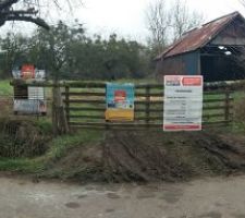Devant du terrain avec panneaux de permis de construire et eau arriv&eacute;e