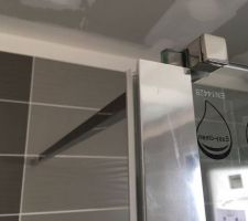 Une cloison en verre de douche qui se termine avec un profil étrange plutôt destiné à joindre 2 vitres ensemble!