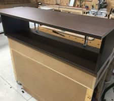 Montage du caisson supérieur pour la fabrication sur mesure de l'aménagement du dressing en mélaminé chêne de fil brun.
