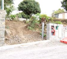 Entrée du terrain avec reseaux en construction. Le tube est derriere le mur et correspond au branchement au tout a l'égout. A gauche de l'entrée, un gros "cap" (grosse roche en créole) qu'il faudra que je détruise si je veux acceder chez moi en voiture...