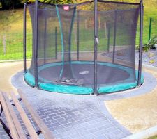 Trampoline enterré avec petite terrasse en pavé