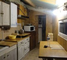La cuisine avec le plan de travail table actuel et au fond cette fameuse porte qu'on voit à gauche juste derriere le micro ondes un peu au dessus de l'egoutoir inox et qu'on ne peut pas vraiement condamner sinon c'etait la place idéale pour l'armoire à four
