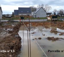 Parcelle 13 : Chez nous.    Parcelle 14 : Chez le voisins.     
La corde est tendue entre nos deux parcelles, reliée aux deux bornes placées par les géomètres.
Nous nous demandons si les fondations du voisin, mais également son futur mur à en juger par la position des fers d'attente des chaînages verticaux, ne seront pas un peu sur notre parcelle.