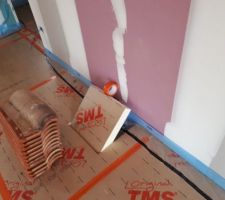 Isolation de sol - salon : isolant découpé pour laisser passer la gaine d'arrivée d'air pour le poêle