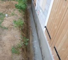 Réalisation d'un chanfrain (petite pente sur la fondation) pour écarter l'eau de la maison.
