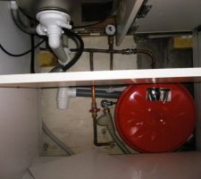 Détail de la plomberie sous évier, après installation du poêle. On y voit la vanne pour remplir le circuit, la soupape  / manomètre de sécurité, et le vase d'expansion.