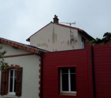 Maison mitoyenne. Partie surélevée où sont visibles des traces d'humidité (jour de pluie)