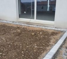 Chemin de propreté de 80 cm de largeur tout autour de la maison délimité par des pavés carrés de 13 cm...