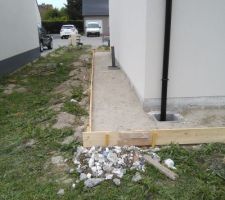 Pr&eacute;paration du coffrage pour couler un trottoir autour de la maison.