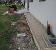 Pr&eacute;paration du coffrage pour couler un trottoir autour de la maison.
