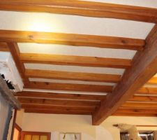 Vue du plafond en poutre et des solives qui entourent la cheminée