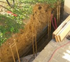 Mis en place des fers à béton verticaux pour le chaînage dans les blocs à bancher.