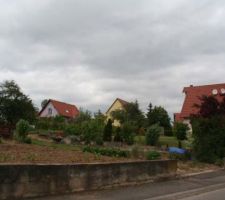 Vue de l'acc&egrave;s au terrain et des maisons environnantes.