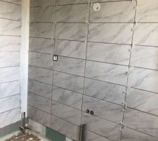 Début de la pose de la faïence aux murs dans les salles de bains.