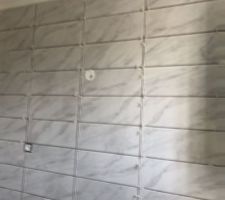 Début de la pose de la faïence aux murs dans les salles de bains.