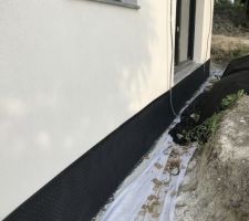 Protection du soubassement avant remise en forme des terres autour de la maison.