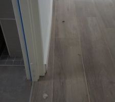 La plinthe suit le placo. Ce n'est pas droit car à cet endroit derrière le placo il y a les sorties d'eau de la douche qui sont trop décalées vers le couloir.