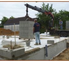 El&eacute;vation des murs et pignons sur le pourtour, des poteaux en b&eacute;ton arm&eacute; (avec ferraillage) dans des parpaings sp&eacute;cifiques (avec trou) relieront les fondations, la dalle plancher, les murs, avec le cha&icirc;nage (avec ferraillage) du haut des murs, cette structure formera un cadre en b&eacute;ton arm&eacute; &eacute;vitant ainsi les d&eacute;formations de l'ensemble et le fissurage de certains ouvrages