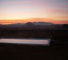 Le soleil se lève sur la piscine.