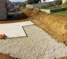Vue globale du terrain avec le terrassement terminé et le toit du garage posé.