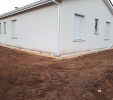 Début des travaux : bordure en bois pour étaler des cailloux tout autour de la maison