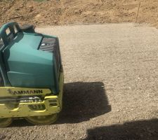 Tassement de la terre tout autour de la maison et du garage pour la réalisation du trottoir, de l'allée et de la terrasse.