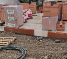 Remblaiement des fouilles autour de la maison après pose des drains.
