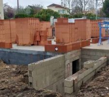 Remblaiement des fouilles autour de la maison après pose des drains.