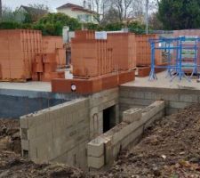 Remblaiement des fouilles autour de la maison après pose des drains.
