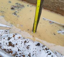 Eau sur et sous la bâche, ferraille dans la boue