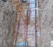 Ferraillage des semelles filantes. Les ferrailles sont calées par des éclats de parpaings. Par endroits la ferraille touche le sol, le maçon m'assure qu'il relève les ferrailles avec une tige au fur et à mesure du coulage de la semelle.