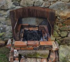 Le barbecue de chantier 2 grosses pierres , un fond de cheminée en fonte et des briques
