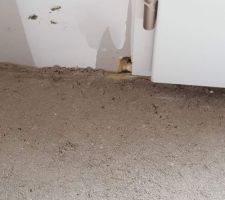 Trou non rebouché au bas de la porte d'entrée