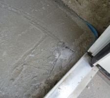 Un morceau de plastique pris dans la dalle.
Malin d'avoir laissé le plastique sur la porte au moment du coulage de la dalle...