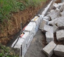 Pose Des premières pierres granit pour montage du mur en pierre sèche