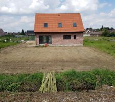 Vue sur l'arrière de la maison et du jardin plat vu depuis le talus