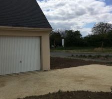 Chemin fait devant la maison avec un gravier blanc.