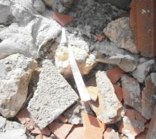 Gravas tout autour de la maison avec déchets tranchants scellés dans le béton déversé par le prestataire Maçonnerie.