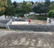 Les murs en blocs à bancher n'ont plus qu'à être remplis de béton, le hérisson est terminé et la pose du TMS est en cours