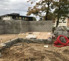 Les murs en blocs à bancher n'ont plus qu'à être remplis de béton, le hérisson est terminé et la pose du TMS est en cours