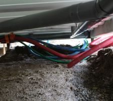 Réseaux sous dalle : Assainissement tuyau PVC, arrivée d'eau (bleu), électricité (rouge), télécom (vert)