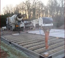 Coulage de la dalle, toupie avec tapis roulant de 13m. Les 2 rectangles en bois sont des réservations pour les récupérateur d'eau de pluie vers une citerne souple qui se trouvera dans le VS du garage